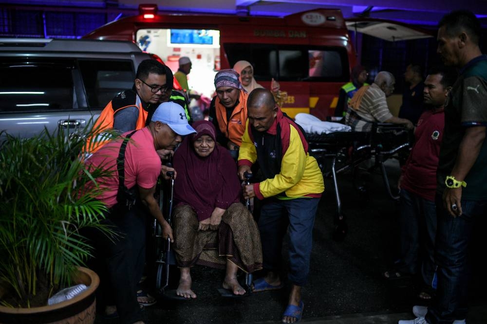 People help evacuate the elderly in flood-hit Baling, Kedah July 5, 2022. — Bernama pic