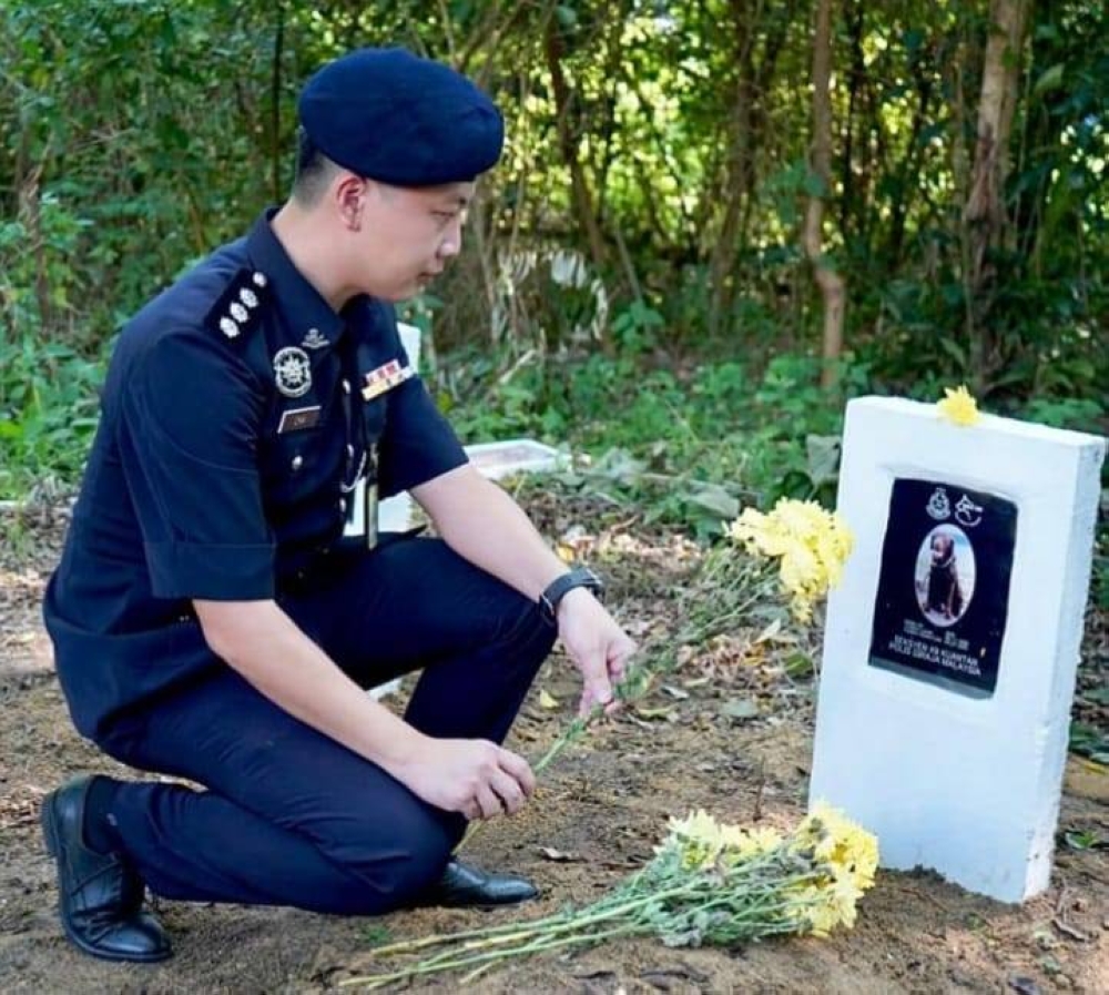 Pahang police contingent's Criminal Investigation Department (CID) technical assistance division (D6) officer-in-charge Assistant Superintendent Chia Che Chau saying goodbye to Bad following the Labrador's death on Monday due to old age. — Picture via Facebook/ JSJ Kontinjen Pahang