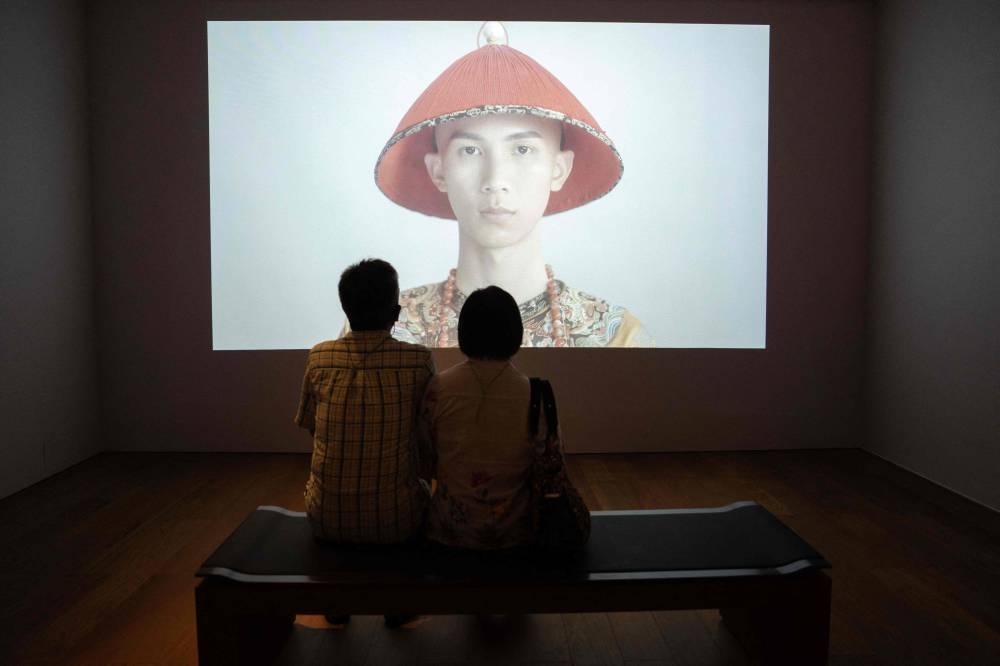 Visitors watch a video during the opening day of the Hong Kong Palace Museum in Hong Kong, July 3, 2022. — AFP pic 