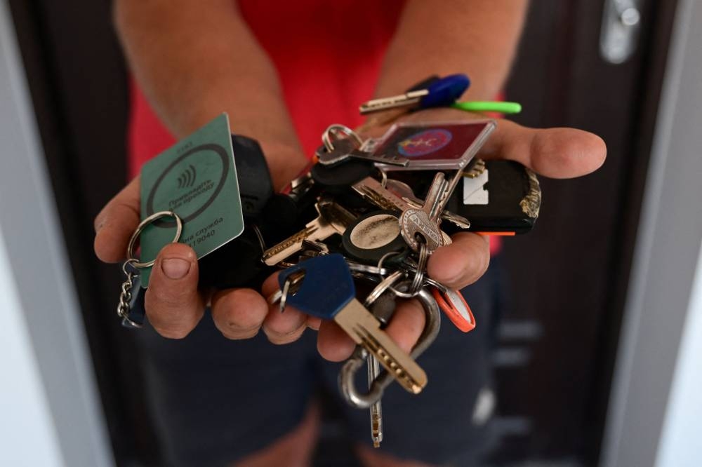 Biologist and gardener Yevgen Yelpitiforov, 37 years old, shows the keys of houses and apartments entrusted to him by people who fled the war, in Irpin, Kyiv region, on July 1, 2022. — AFP pic