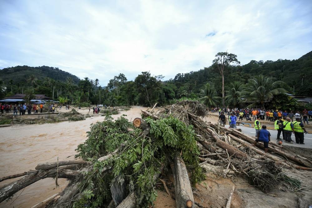 A pile of logs and debris is seen along Sungai Latar Celak Iboi following a massive flood which destroyed the bridge here, in Baling July 5, 2022. — Bernama pic