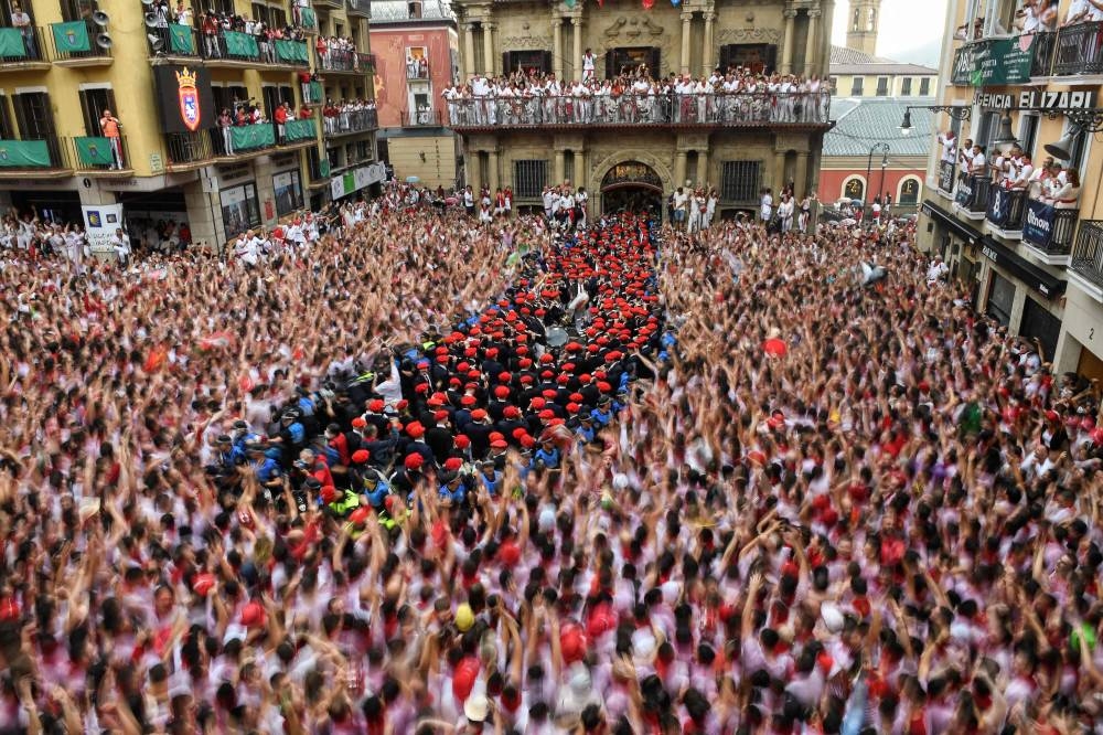 Participants celebrate as the ‘Pamplonesa’ municipal music band performs during the ‘Chupinazo’ (start rocket) opening ceremony to mark the kick-off of the San Fermin Festival outside the Town Hall of Pamplona in northern Spain, July 6, 2022. — AFP pic 