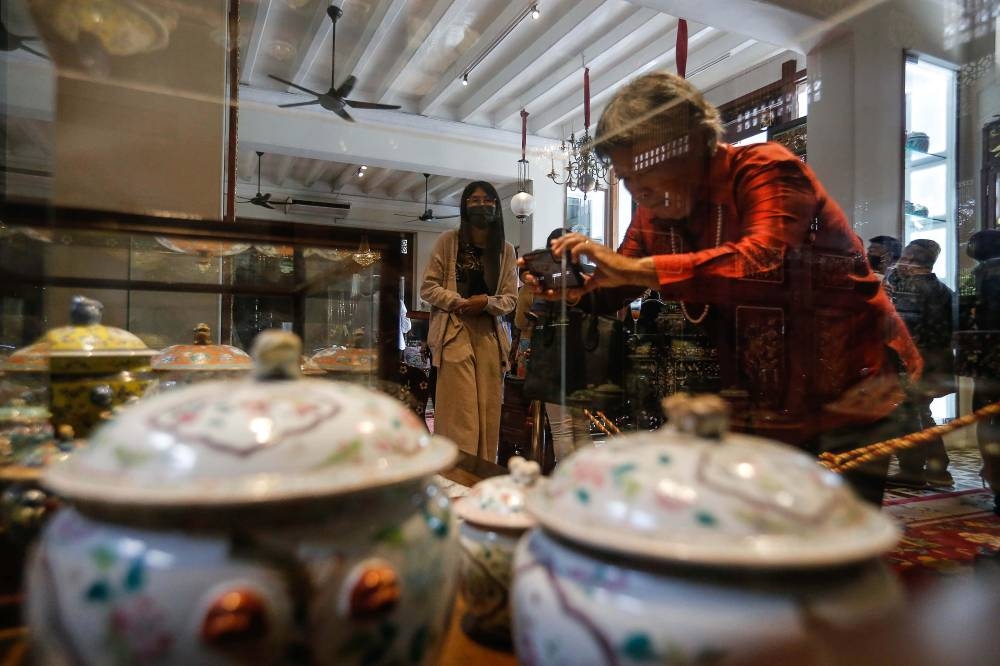 A visitor admires the ‘Kam Cheng’ pot on display at the Kam Cheng Cache exhibition at Seven Terraces in George Town July 6, 2022. ― Picture by Sayuti Zainudin