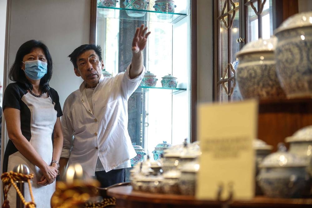 Seven Terraces owner Chris Ong speaks to a guest during the Kam Cheng Cache exhibition at Seven Terraces in George Town July 6, 2022. ― Picture by Sayuti Zainudin