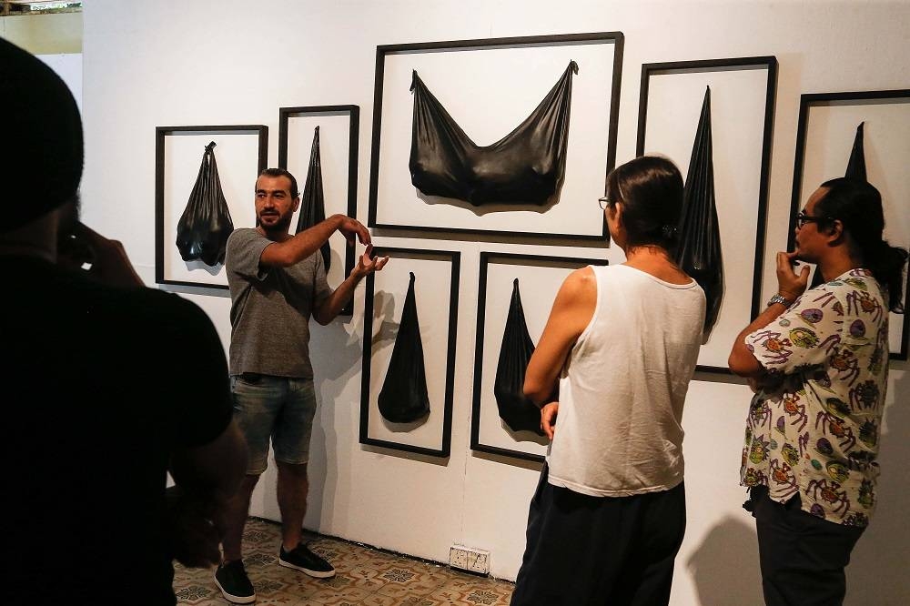 Aboud Fares explaining his artwork called ‘Bagged’ at the Tu7oh Exhibition in George Town July 6, 2022. ― Picture by Sayuti Zainudin