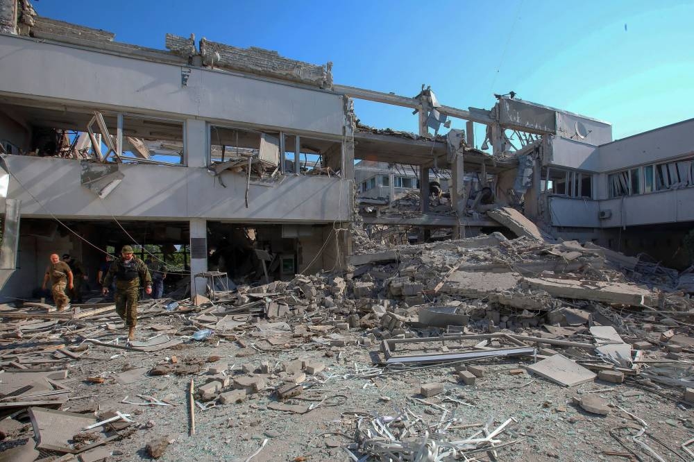 Police officers inspect a building of HS Skovoroda Kharkiv National Pedagogical University damaged by a Russian missile strike, as Russia's attack on Ukraine continues, in Kharkiv, Ukraine July 6, 2022.  ― Reuters pic