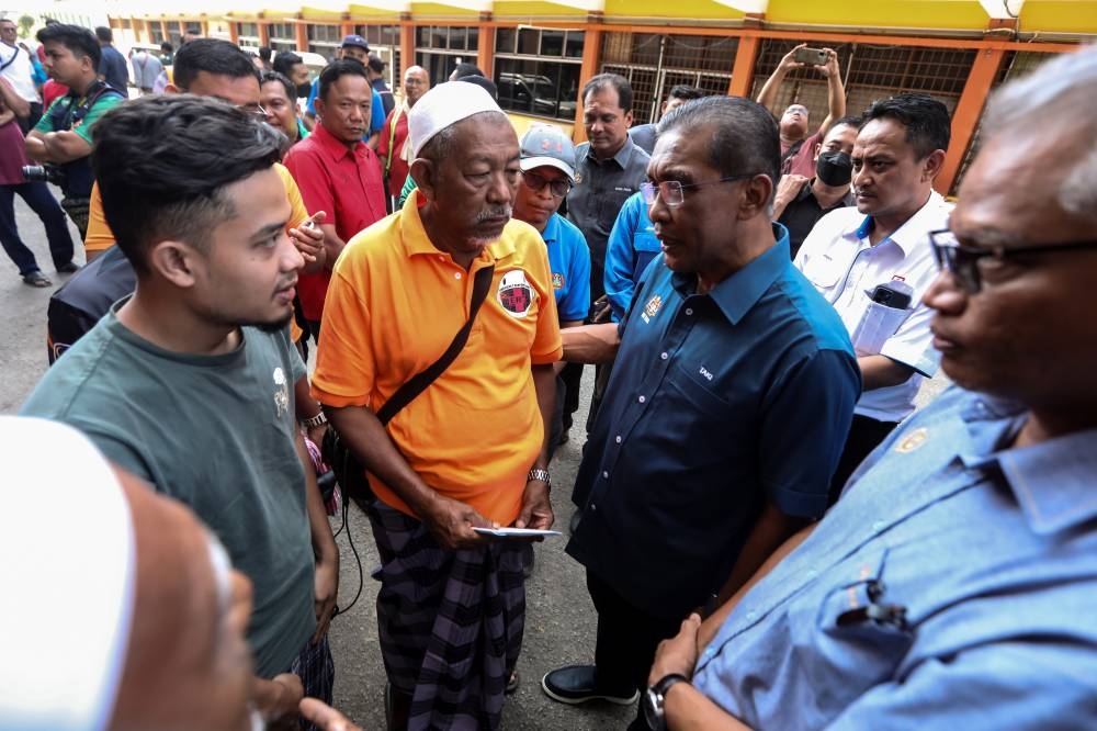 Energy and Natural Resources Minister Datuk Seri Takiyuddin Hassan talks to flood evacuees during a visit to three temporary evacuation centres in Baling, July 7, 2022. — Bernama pic 
