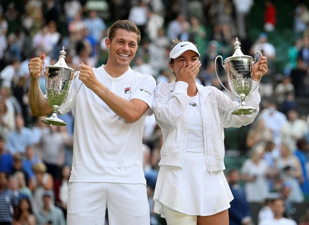 Desirae Krawczyk and Britian's pose for a photograph with their trophies as they celebrate winning the mixed doubles final at the All England Lawn Tennis and Croquet Club, London July 7, 2022. — Reuters pic 