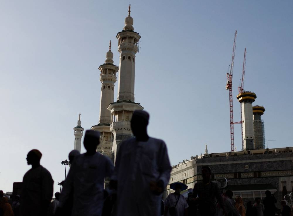 Muslims pilgrims walk outside  the Grand mosque in the holy city of Mecca, Saudi Arabia July 5, 2022. — Reuters pic