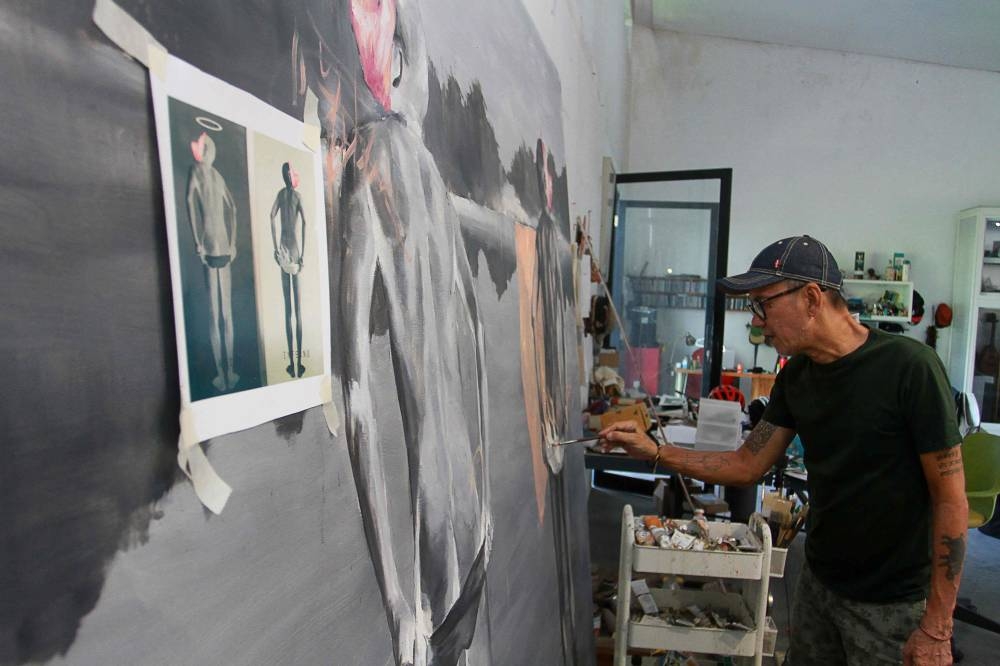 This picture taken on June 10, 2022 shows Indonesian artist Agus Suwage working at his studio in Yogyakarta. — AFP pic
