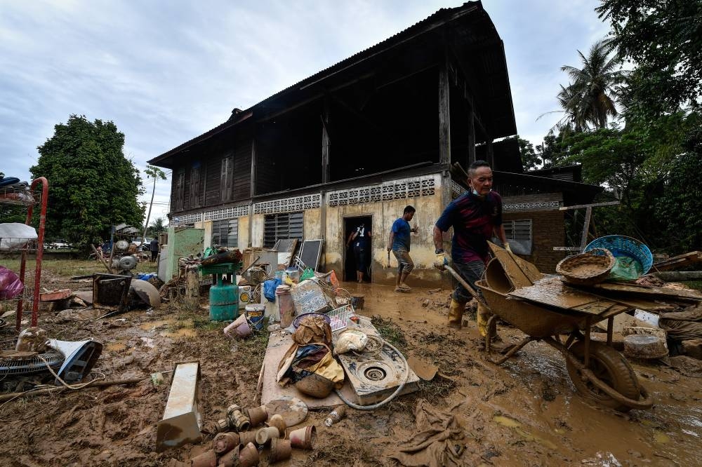 Residents are seen cleaning up the mess after the flood in Kampung Iboi, Kupang July 5,2022. ― Bernama pic