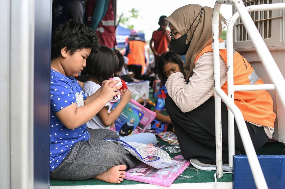 Children who were evacuated from their homes due to the floods take part in activities at a local social support centre in Baling July 9, 2022. — Bernama pic