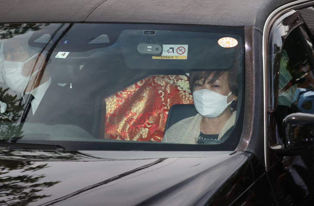 Akie Abe, widow of the late Japanese prime minister Shinzo Abe, returns to her residence in a hearse transporting the body of her husband, in Tokyo on July 9, 2022. — AFP pic