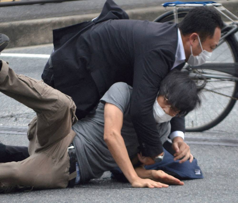 A man, believed to be a suspect shooting former Japanese Prime Minister Shinzo Abe is held by police officers at Yamato Saidaiji Station in Nara, Nara Prefecture on July 8, 2022 in this photo taken by the Yomiuri Shimbun. ― Reuters pic