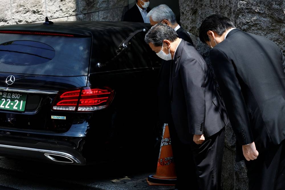 LDP officials pray to the vehicle believed to be carrying the body of former Japanese Prime Minister Shinzo Abe, who was shot while campaigning for a parliamentary election, at his residence in Tokyo, Japan July 9, 2022. ― Reuters pic