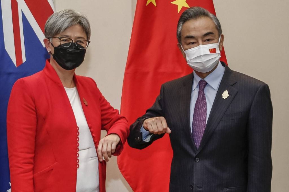 Australia's Foreign Minister Penny Wong (left) bumps elbows with China's Foreign Minister Wang Yi during their bilateral meeting on the sidelines of G20 Foreign Ministers Meeting in Nusa Dua on Indonesia's resort island of Bali on July 8, 2022. — AFP pic