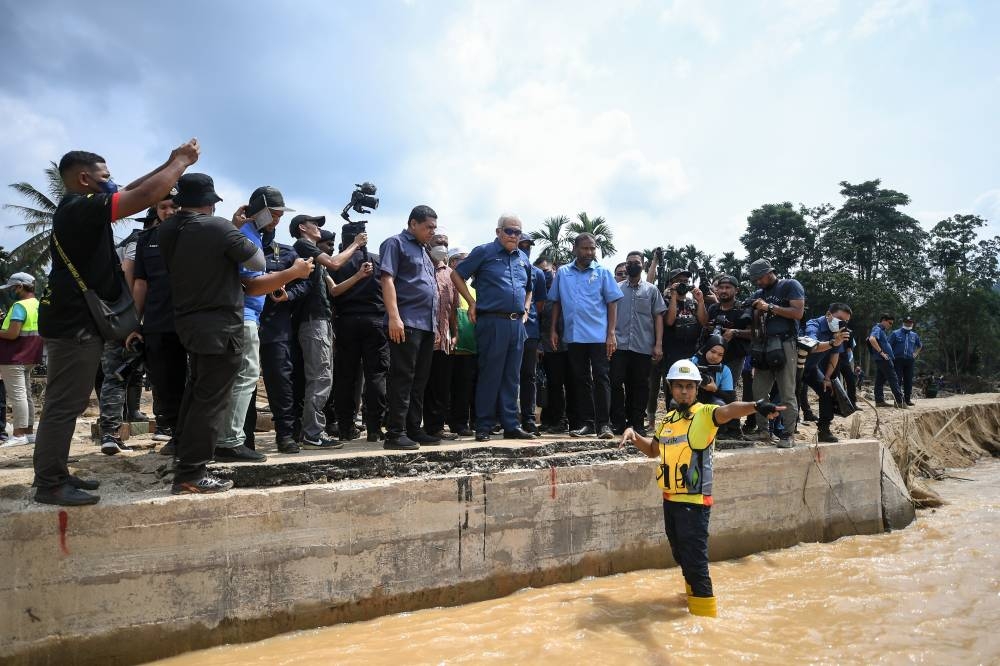 Datuk Seri Hamzah Zainuddin and Baling member of parliament Datuk Seri Abdul Azeez Abdul Rahim visit the site of a bridge destroyed by the floods in Kampung Iboi July 8, 2022. — Bernama pic
