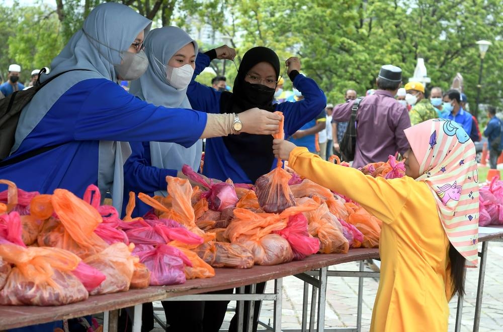 Workers hand out meat to the public in conjunction with Hari Raya Aidiladha at the Sultan Salahuddin Abdul Aziz Shah mosque in Shah Alam July 10, 2022. — Bernama pic
