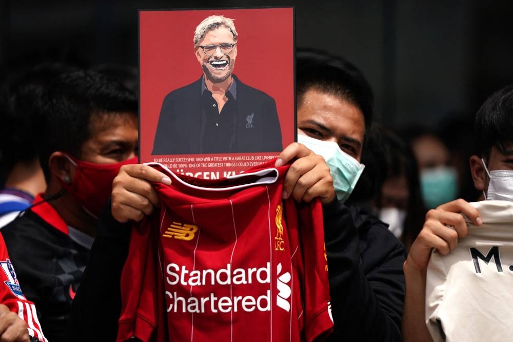 Liverpool fans react as the Liverpool team arrive in Bangkok. — Reuters pic