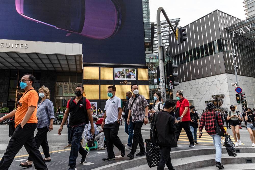 People are seen wearing protective masks as they walk along the Bukit Bintang shopping area in Kuala Lumpur May 19, 2022. — Picture by Firdaus Latif    