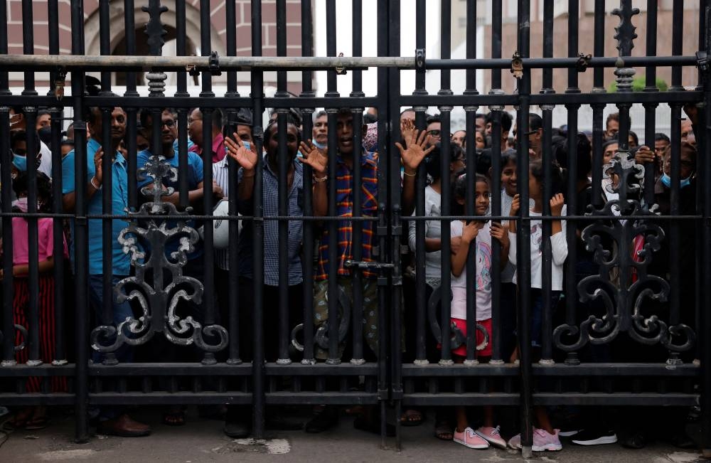 People wait behind a gate to visit the President's house on the day after demonstrators entered the building, after President Gotabaya Rajapaksa fled, amid the country's economic crisis, in Colombo, Sri Lanka July 10, 2022. — Reuters pic