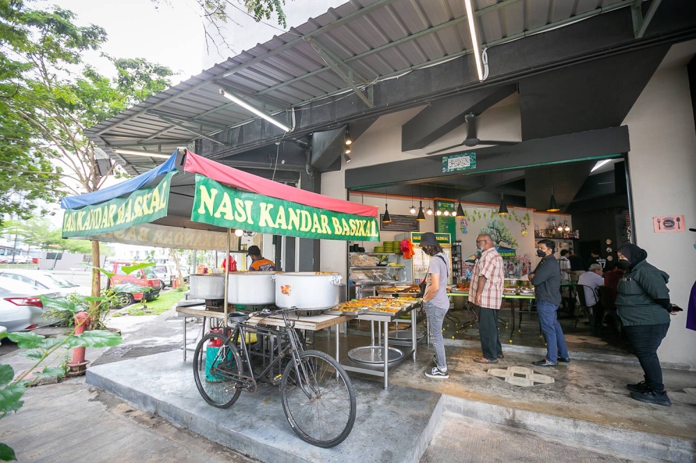 Customers begin queuing at Nasi Kandar Basikal before 10.30am to taste the signature Nasi Kandar dishes, June 23, 2022. — Picture by Devan Manuel