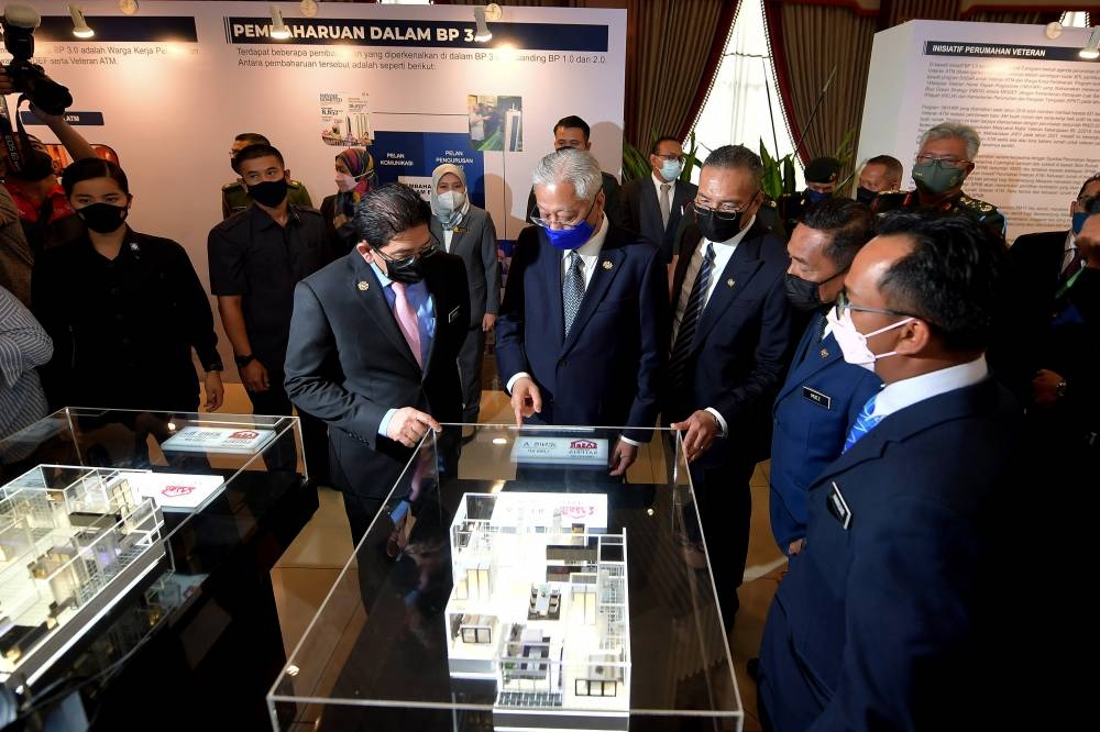 Prime Minister Datuk Seri Ismail Sabri Yaakob looks at house layout plans at the launch of the Defence Ministry’s Housing Blueprint 3.0 in Kuala Lumpur, July 13, 2022. — Bernama pic 