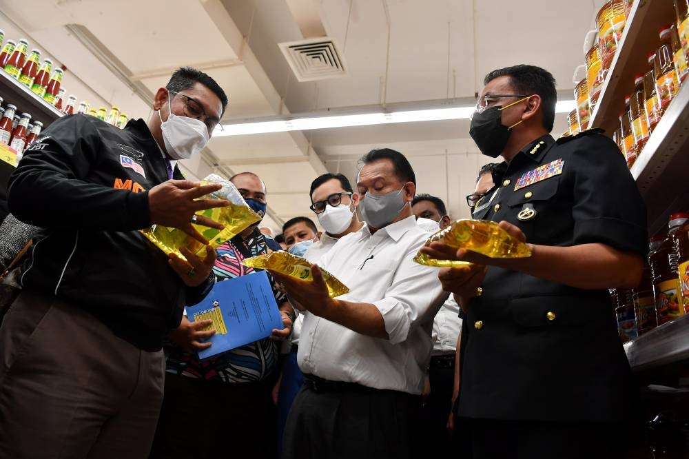 Domestic Trade and Consumer Affairs Minister Datuk Seri Alexander Nanta Linggi (centre) and Youth and Sports Minister Datuk Seri Ahmad Faizal Azumu during a walkabout to inspecting and monitoring the price of goods a supermarket in Putrajaya, July 13, 2022. — Bernama pic 