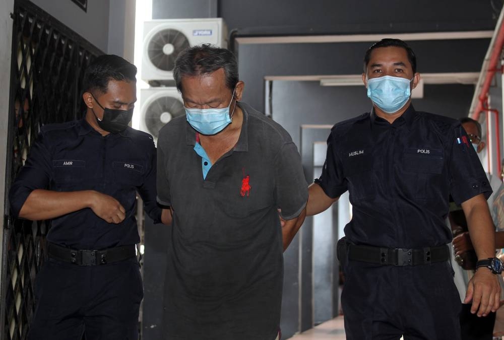 Ng Chun Ming (centre) at the Ipoh Magistrates’ Court, July 14, 2022. — Bernama pic 