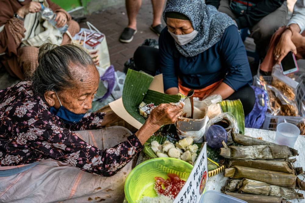 Satinem’s stall is surrounded daily by dozens of fascinated customers who watch her every move and document the process with their phones. — AFP pic