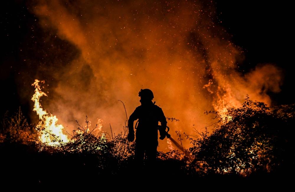 A firefighter tackles a forest fire around the village of Eiriz in Baiao, north of Portugal  July 15, 2022. — AFP pic