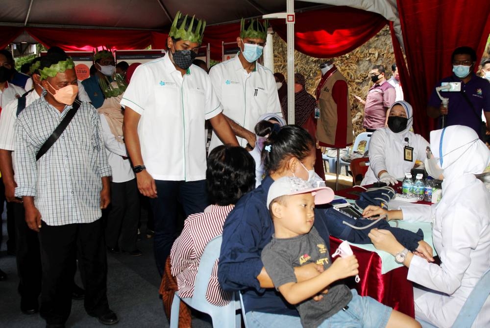 Health Minister Khairy Jamaluddin (second left) chats with the Orang Asli community at the launch of the Orang Asli Health Survey at the Sahom Community Hall, Kampar July 16, 2022. — Bernama pic