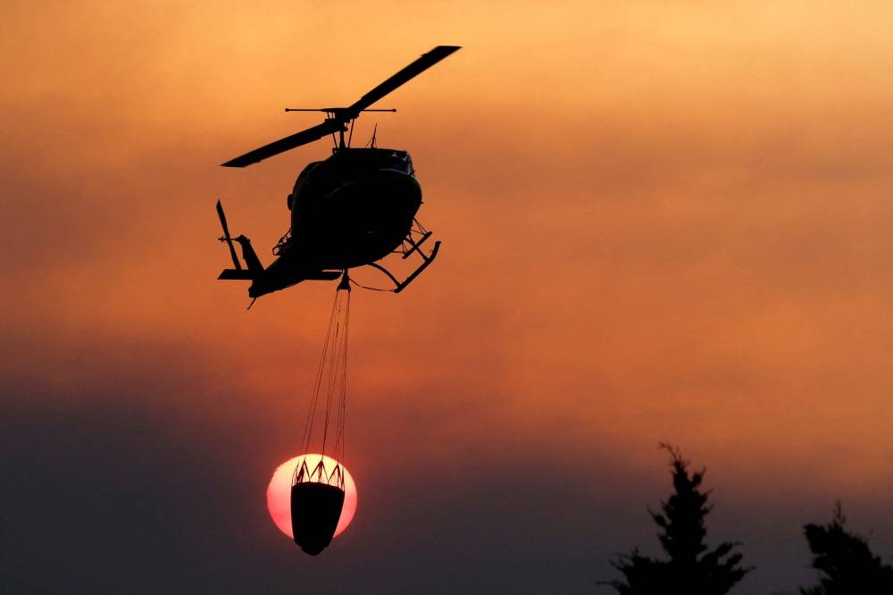 Helicopter refills water while working to extinguish a wildfire in Alhaurin el grande, Spain, July 15, 2022. — Reuters pic