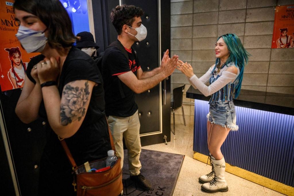 In this photo taken on July 2, 2022, Korean-American K-pop star AleXa (right), who recently won the American Song Contest, greets her fans after a mini concert at a television studio in Seoul. — AFP pic