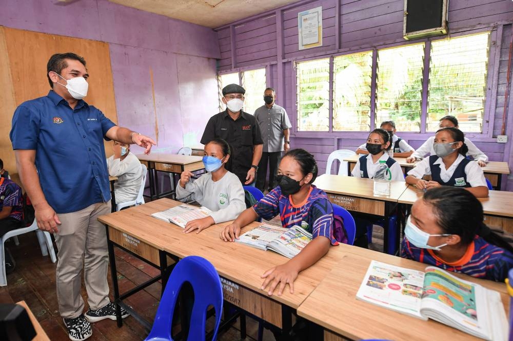 Senior Education Minister Datuk Mohd Radzi Md Jidin speaks to students of Sekolah Kebangsaan (SK) Ulu Ansuan near Telupid, Sabah, July 18, 2022. With him is Agriculture and Food Industries Minister Datuk Seri Ronald Kiandee, who is also Beluran MP. — Bernama pic 
