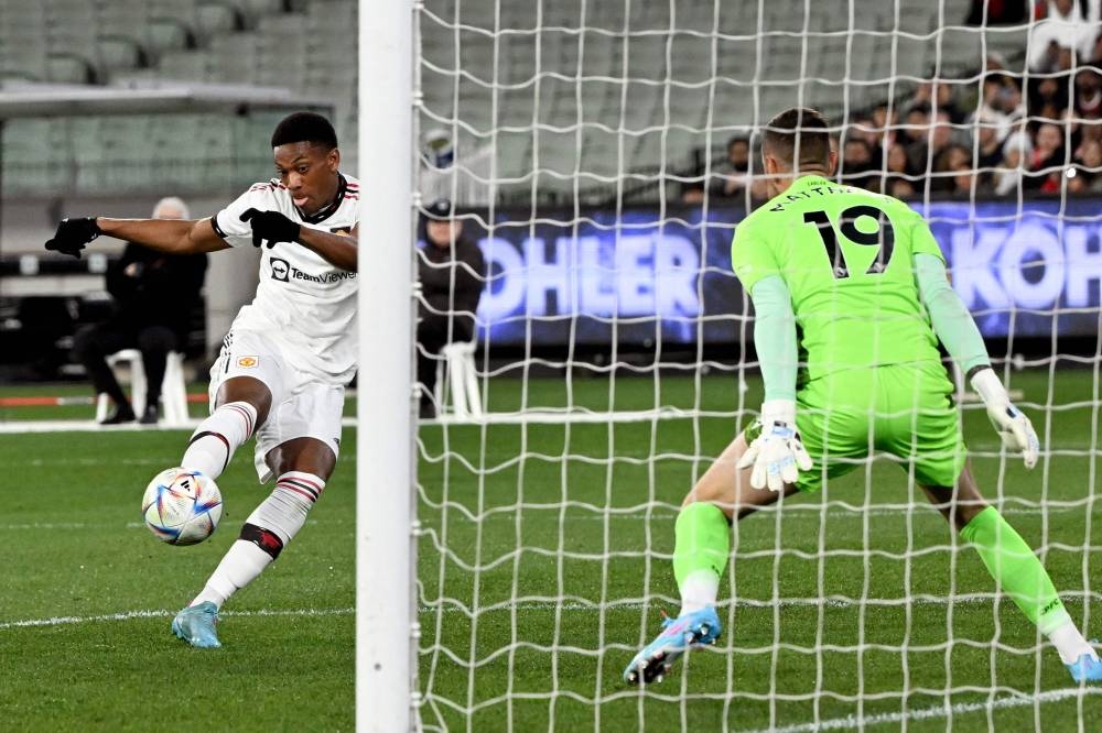Manchester United player Anthony Martial scores past Crystal Palace goalkeeper Remi Matthews during the pre-season match against Crystal Palace at the Melbourne Cricket Ground (MCG), July 19, 2022, in Melbourne. — AFP pic 
