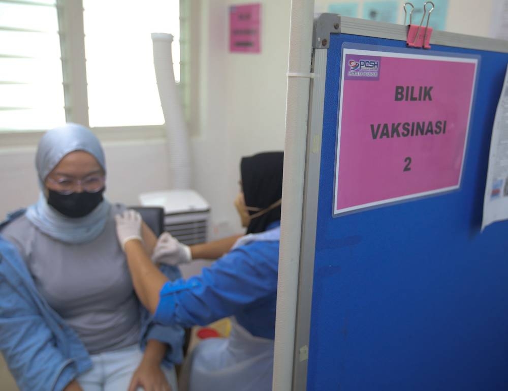A health worker administers a Covid-19 vaccine booster dose at the Perak Community Specialist Hospital in Ipoh March 1, 2022. — Picture by Farhan Najib