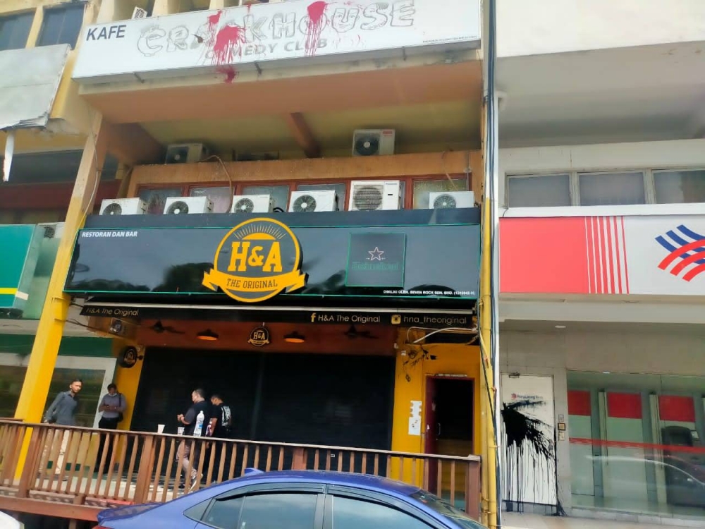 Paint is seen on the signboard of the Crackhouse Comedy Club and a door of the Hong Leong Bank branch in Taman Tun Dr Ismail on July 19, 2022. — Picture courtesy of the Royal Malaysia Police