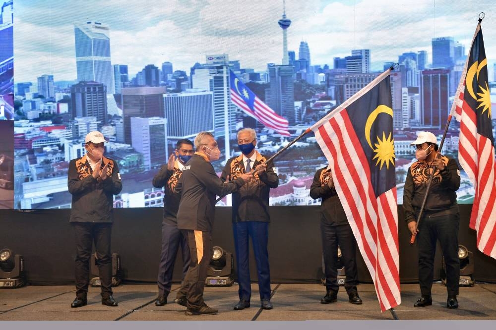 Prime Minister Datuk Seri Ismail Sabri Yaakob hands the  Jalur Gemilang to Chef-de-mission (CDM) of the national contingent to the 2022 Birmingham Commonwealth Games Datuk Shahrul Zaman Yahya at a hotel in Kuala Lumpur July 19, 2022. — Bernama pic