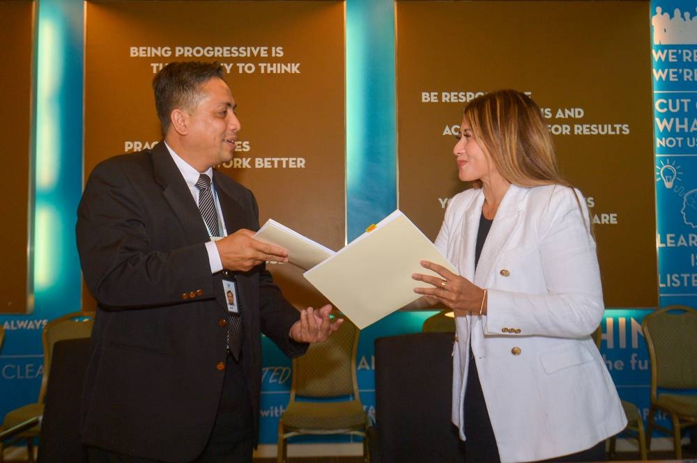MAHB senior general manager for commercial services Hani Ezra Hussin and Meru Utama director Aznur Azizuddin (right) exchange agreements at Malaysia Airports Corporate Office in Sepang on July 21, 2022. — Picture by Shafwan Zaidon