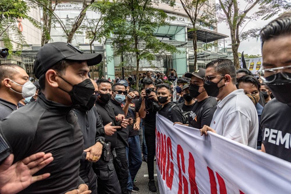 Protesters face off with police officers during the 'Turun' protest at Sogo shopping complex in Kuala Lumpur, July 23, 2022. — Picture by Firdaus Latif