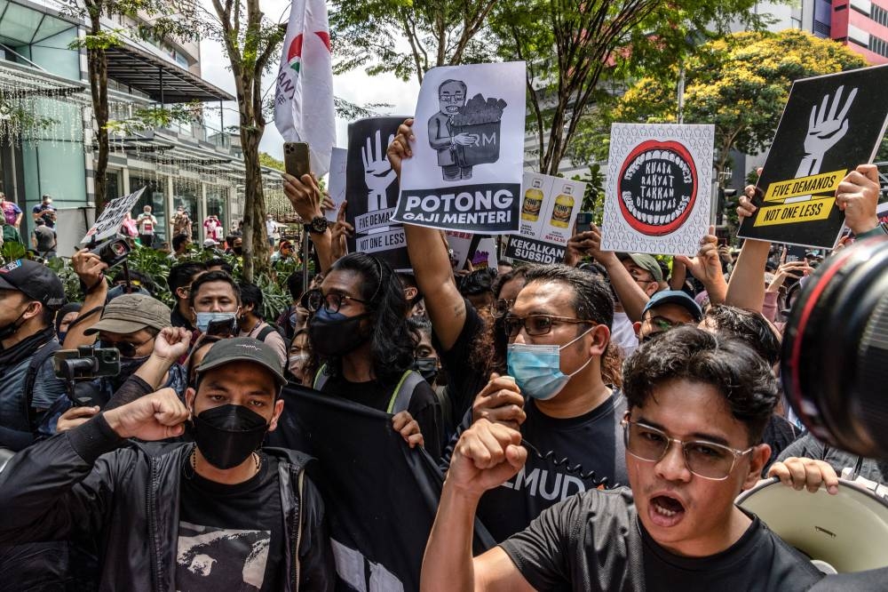 Protesters hold placards during the 'Turun' protest at Sogo shopping complex in Kuala Lumpur, July 23, 2022. — Picture by Firdaus Latif