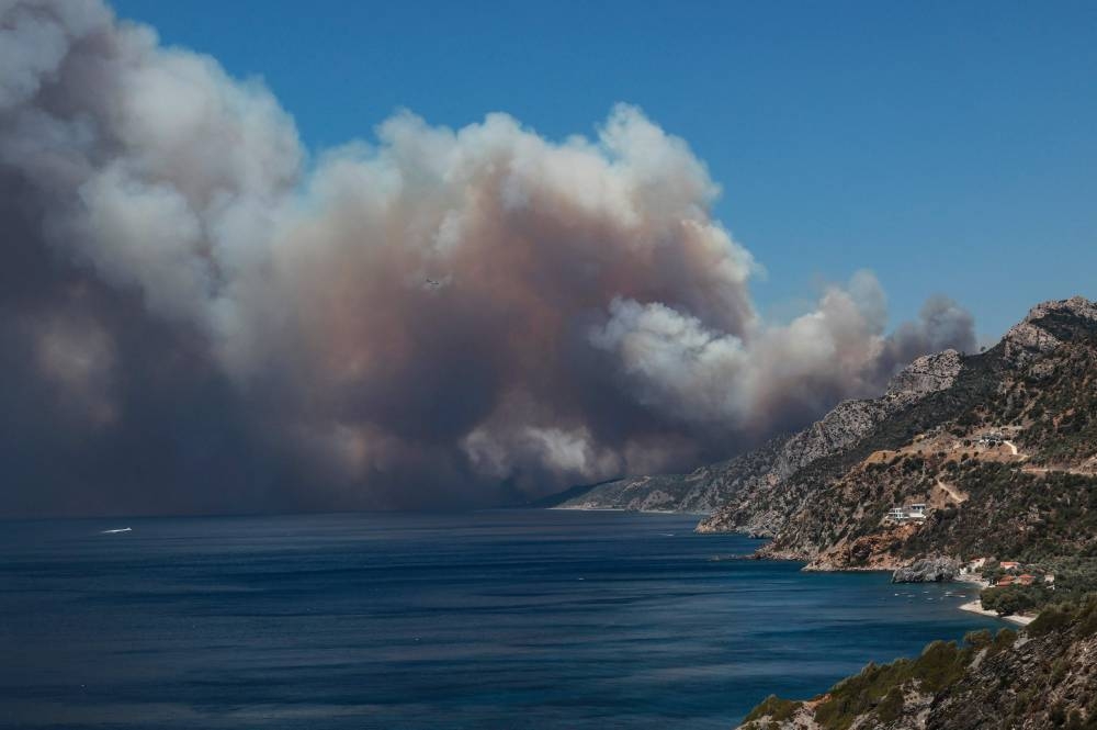 The smoke of a wildfire billows as it approaches Vatera coastal resort on the eastern island of Lesbos on July 23, 2022. ― AFP pic