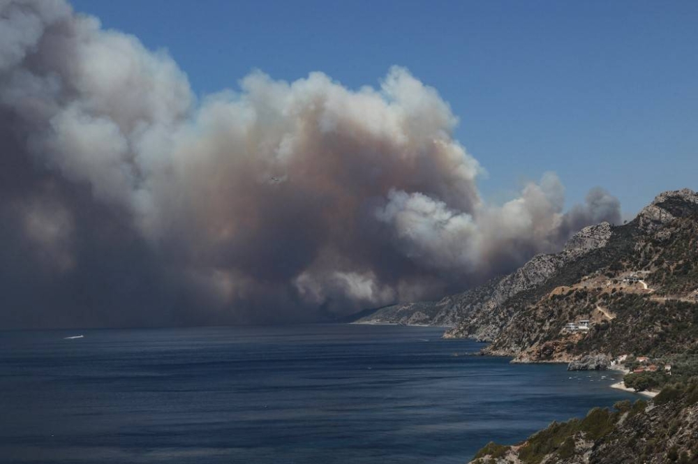 The smoke of a wildfire billows as it approaches Vatera coastal resort on the eastern island of Lesbos on July 23, 2022. Residents were evacuated as the wildfire threatened properties. — AFP pic