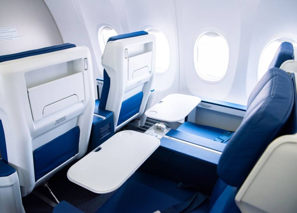 The new business class seats are equipped with a one-piece table that stores in the armrest.  - Photo via SoyaCincau