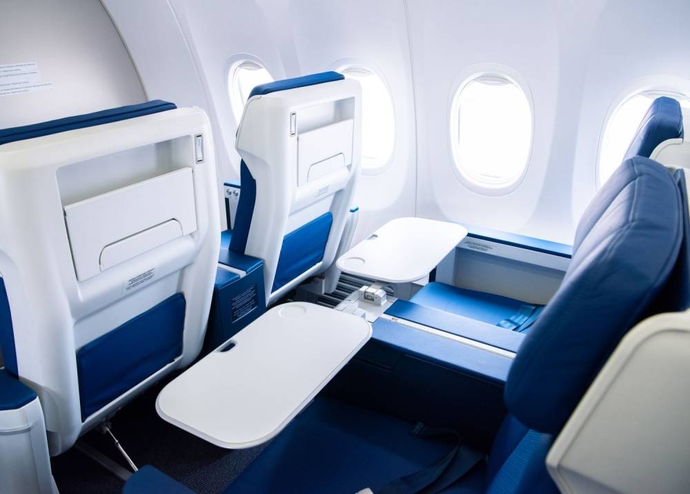 The new business class seats come with a one-piece tray table that’s stowed in the armrest.  — Picture via SoyaCincau