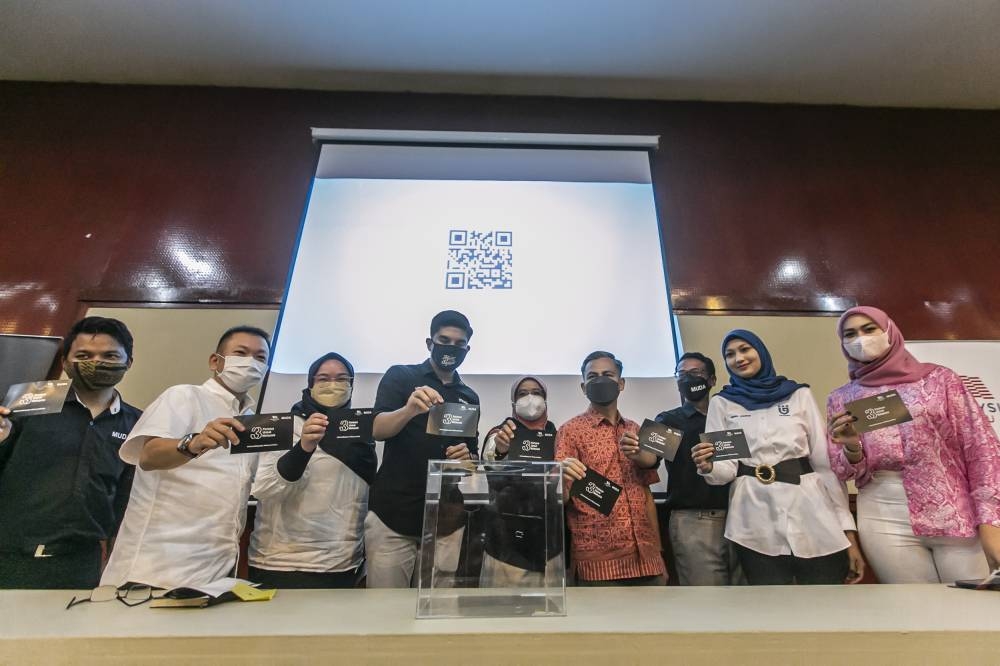 2022 年 7 月 24 日，慕达在吉隆坡和雪兰莪华人大会堂（KLSCAH）推出的马来西亚 Maju 60 天外展计划启动仪式上，慕达总裁赛沙迪阿都拉曼（中）与其他国会议员和议员一起举着明信片。 — 图片由哈里·安加拉拍摄