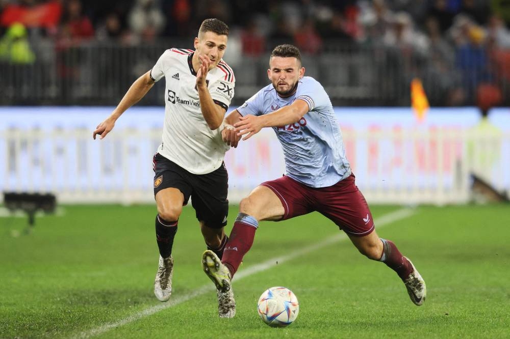 John McGinn of Aston Villa (right) and Manchester United player Diogo Dalot fight for the ball during a friendly match at the Optus Stadium in Perth on July 23, 2022. — Reuters pic