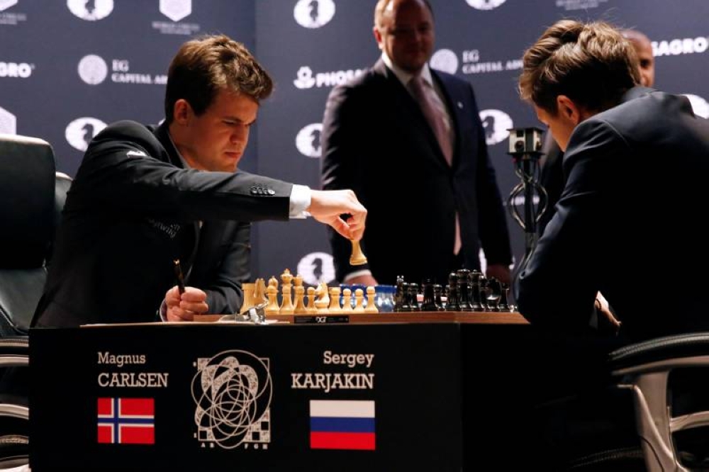 Magnus Carlsen (left), of Norway, makes a move against Sergey Karjakin, of Russia, during their opening match in the 2016 World Chess Championship in New York November 11, 2016. — Reuters pic