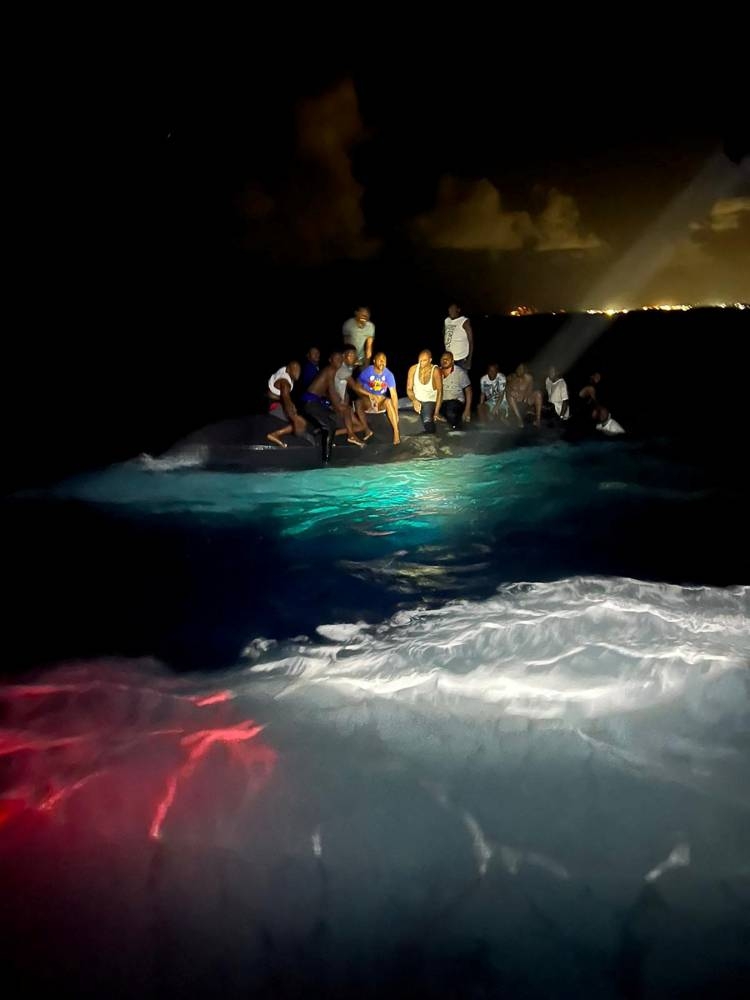 Survivors of a migrant boat that capsized perch on the overturned vessel off the coast of New Providence island, Bahamas July 24, 2022. — Picture courtesy of Royal Bahamas Defence Force/Handout via Reuters